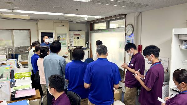 新人研修にて消防署の方から設備について説明を受けている。