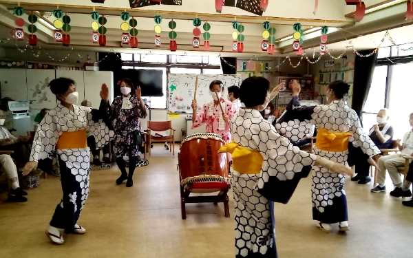 輪になり盆踊りを踊っている