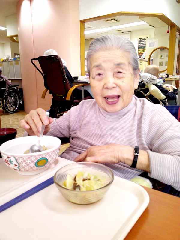 郷土料理を食べて美味しいといった顔をされているお客様