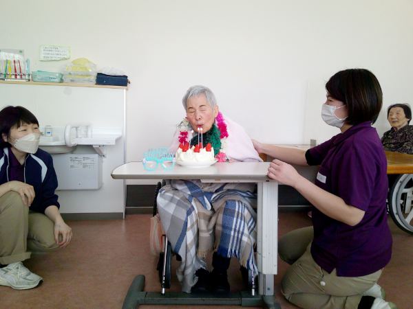 ケーキの蝋燭を吹き消されるお客様
