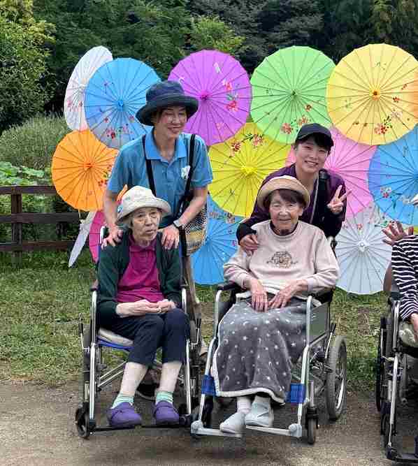 菖蒲園で記念撮影をする職員とお客様
