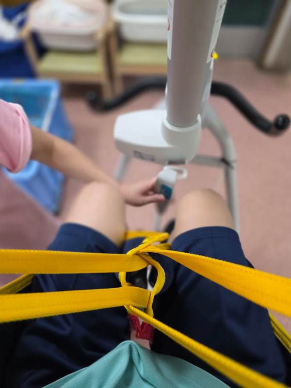 電動リフトに座っている職員