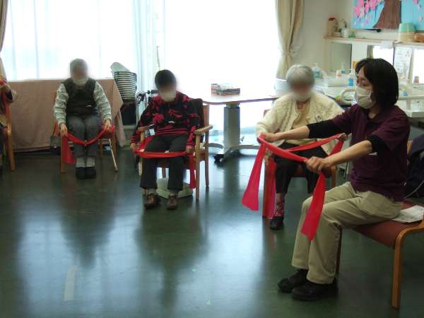 機能訓練指導員とお客様がセラバンド体操をしているところを