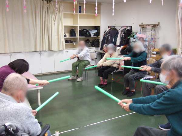 棒を使って上半身を伸ばす体操をしているところ