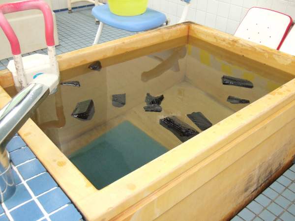 一般浴の浴槽に備長炭が浮いているところ